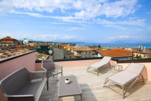 een balkon met stoelen en uitzicht op de stad bij Casa Tunina in Desenzano del Garda