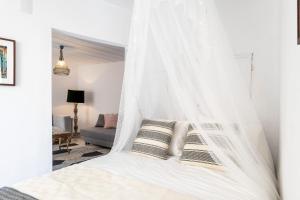 リスボンにあるLisbon Alfama Street Viewのベッドルームに天蓋付きの白いベッド1台