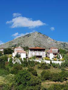 un edificio en una colina con una montaña en el fondo en Hotel Metoxi en Spiliá