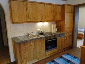 una cocina con armarios de madera y fregadero en Appartement Gipfelsturm, en Haus im Ennstal