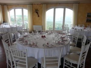 Zimmer mit einem Tisch mit weißen Tischen und Stühlen in der Unterkunft Bricco Rosso in Farigliano