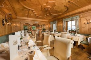 ein Esszimmer mit weißen Tischen und Stühlen in der Unterkunft Bärenhotel in Olang
