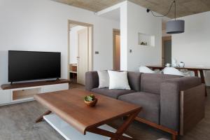 a living room with a couch and a table at JBX Resort Apartments Lipno in Lipno nad Vltavou