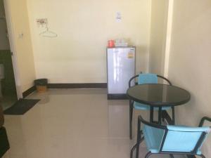 a dining room with a table and a refrigerator at Bannrommai Sattahip in Sattahip