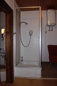 a bathroom with a shower with a tub and a sink at Ferienhaus Schwärzer in Bischofsgrün