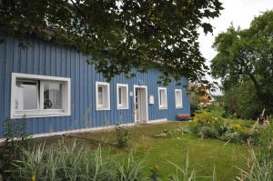a blue house with white windows and a yard at Ferienhaus Schwärzer in Bischofsgrün