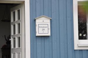 un reloj en el lateral de un edificio azul en Ferienhaus Schwärzer, en Bischofsgrün