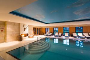 a pool in a hotel room with a ceiling that has a painting on it at Hotel Gut Klostermühle natur resort & medical spa in Alt Madlitz