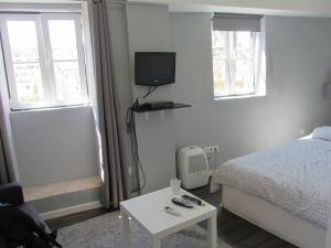 リスボンにあるHouse Mourariaのベッドルーム(ベッド1台、テレビ、テーブル付)