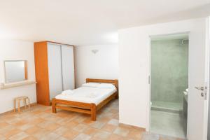 a small bedroom with a bed and a shower at Afroditi Pansion in Agios Nikitas
