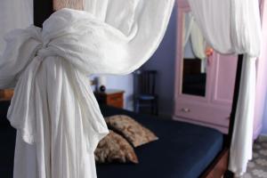 a bedroom with a bed with white curtains at La Via delle Biciclette in Palermo