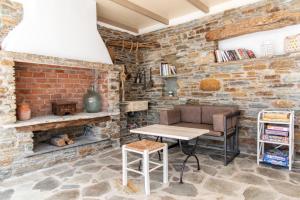 a living room with a table and a brick wall at Porto Bello Tinos in Agios Ioannis