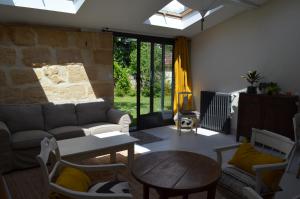 a living room with a couch and a table at Le Jardin Secret in Gauriac