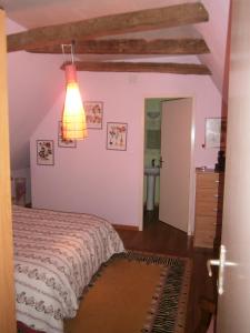 - une chambre avec un lit et une lumière sur le mur dans l'établissement Le Bukarou, à Saint-Léon-dʼIssigeac