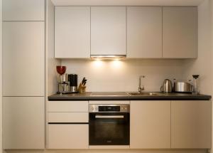 a kitchen with white cabinets and a stove at Appartements Erwin Hüttl III in Neukirchen am Großvenediger