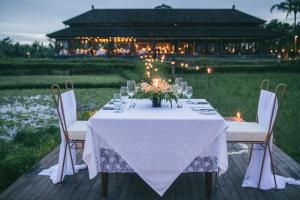 
a dining room table set up for a party at Tanah Gajah, a Resort by Hadiprana in Ubud
