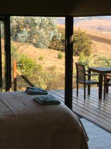 a view from a balcony of a house with a view of the ocean at Over the Edge Cottage in Underberg
