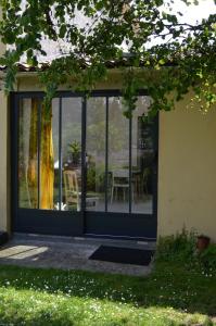 Une porte ouverte s'ouvre sur une terrasse avec une table et des chaises. dans l'établissement Le Jardin Secret, à Gauriac