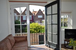 een woonkamer met een deur naar een balkon bij Ons Pakhuisje Harlingen in Harlingen