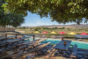 a group of tables and chairs next to a swimming pool at Felix Unite Provenance Camp in Noordoewer