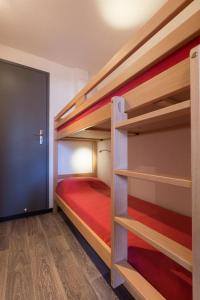 a bedroom with two bunk beds with a red bed at Vacanceole - Résidence Andromede in Les Deux Alpes