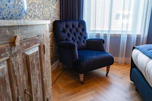 a chair sitting in the corner of a room next to a window at Boutiquehotel 't Gerecht in Heerenveen