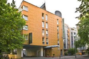 - un bâtiment en briques dans une rue arborée dans l'établissement Hotel Delta am Potsdamer Platz, à Berlin