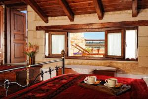 a bedroom with a bed and a window and a tub at Strofilia Villas Crete in Sellía