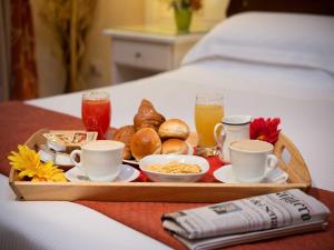 a tray of breakfast foods and drinks on a bed at Residenza Domiziano in Rome