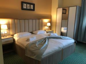 um quarto com uma cama grande com duas toalhas em Mein Palace Hotel em Okriftel