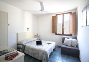 a bedroom with a bed and a chair with a laptop on it at Il Ghiro Guest House in Florence