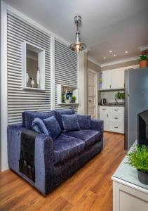 een woonkamer met een blauwe bank in een keuken bij Sodic Westown Residence1-near Elnada hospital in ‘Izbat Yūsif Barrādah