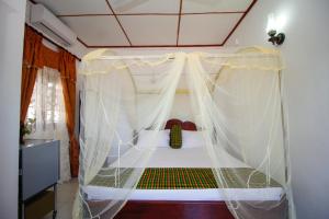 العائلة المضيفة بينتوتا في بينتوتا: غرفة نوم بسرير مع مظلة