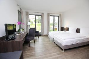 Dormitorio con cama, escritorio y TV en Gasthof Schiller bei Bamberg, en Strullendorf