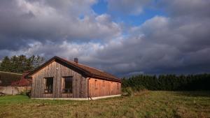 an old barn in a field with a cloudy sky at Kasteheina kodu in Voka