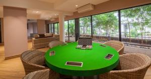 ロナバラにあるVilla 41 by StayVista - A chic retreat with a pool, poker table, and a theater roomの緑のテーブル(椅子、ノートパソコン付)