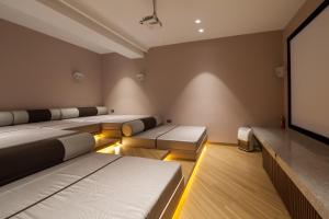 ロナバラにあるVilla 41 by StayVista - A chic retreat with a pool, poker table, and a theater roomのベッド4台と薄型テレビ付きの部屋