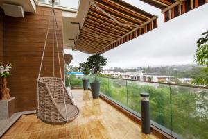ロナバラにあるVilla 41 by StayVista - A chic retreat with a pool, poker table, and a theater roomのバルコニー(スイングチェア付)
