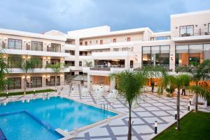 an exterior view of a building with a swimming pool at Porto Platanias Beach Resort & Spa in Plataniás