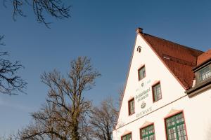 グリューンヴァルトにあるSchlosshotel Grünwaldの赤い屋根と木の白い建物