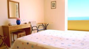 a bedroom with a bed and a desk and a mirror at Creta Spirit in Plakias