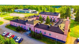 a large pink building with cars parked in a parking lot at LentoHotelli in Kauhava