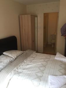 a bed in a room with a bathroom with a toilet at Fabulous Dockside Apartment in Liverpool