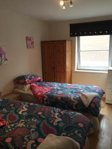 a bedroom with two beds and a window at Fabulous Dockside Apartment in Liverpool