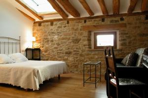 a bedroom with a bed and a stone wall at Casa Baquedano in Murugarren