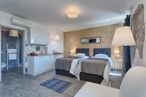 two beds in a room with a kitchen at Luxury flats in city centre in Pula