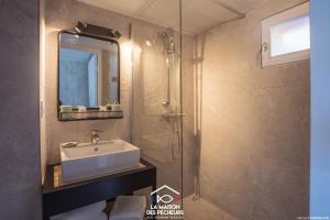 uma casa de banho com um lavatório e um espelho em La maison des pêcheurs em Viviers-du-Lac