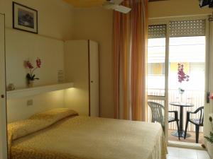 una camera con letto e un balcone con tavolo di Hotel Paron a Bibione