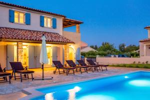 a villa with a swimming pool in front of a house at Villa Leticia in Hreljići