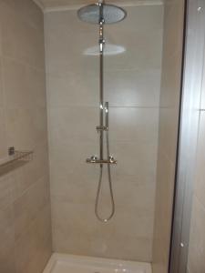 a shower with a shower head in a bathroom at le charme de la campagne in mesen